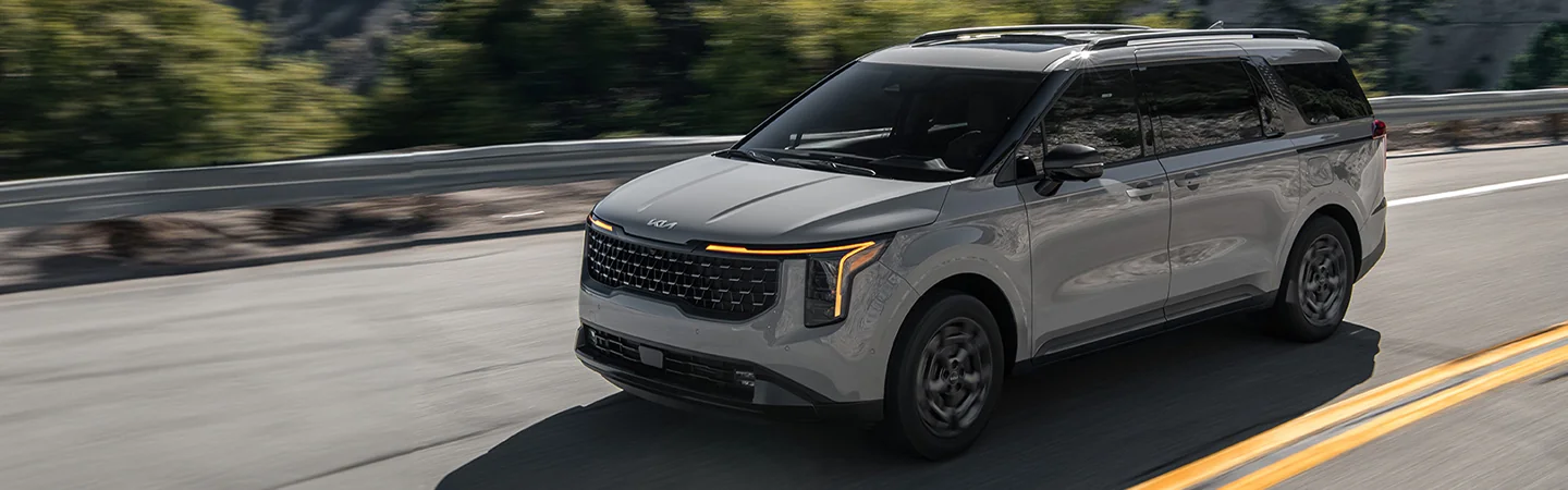 2025 Kia Carnival MPV Hybrid LXS in motion on mountian highway