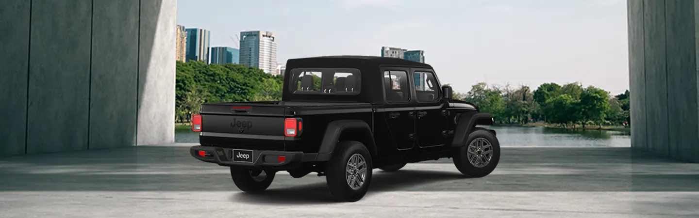 Back view of a parked black 2025 Jeep Gladiator by a city park
