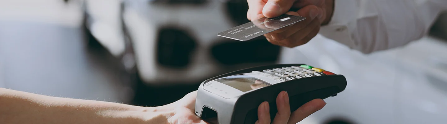 two hands doing a credit card transaction with credit card and card reader being held