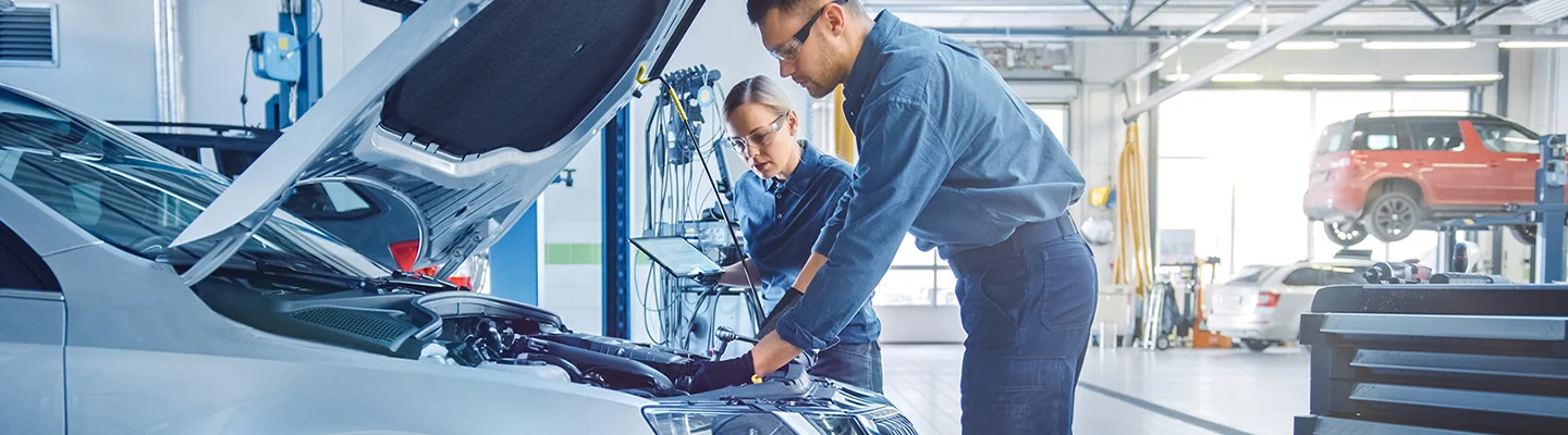auto mechanics working on car in service bays