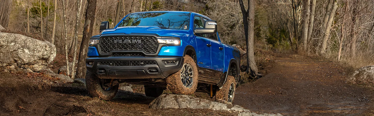 2026 RAM 1500 driving over rocks in the woods