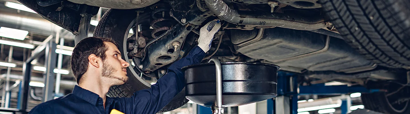 car mechanic working under car on a lift