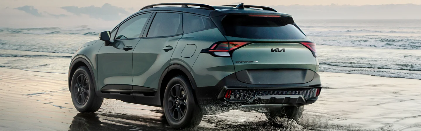 Back view of a 2025 Kia Sportage parked on the beach