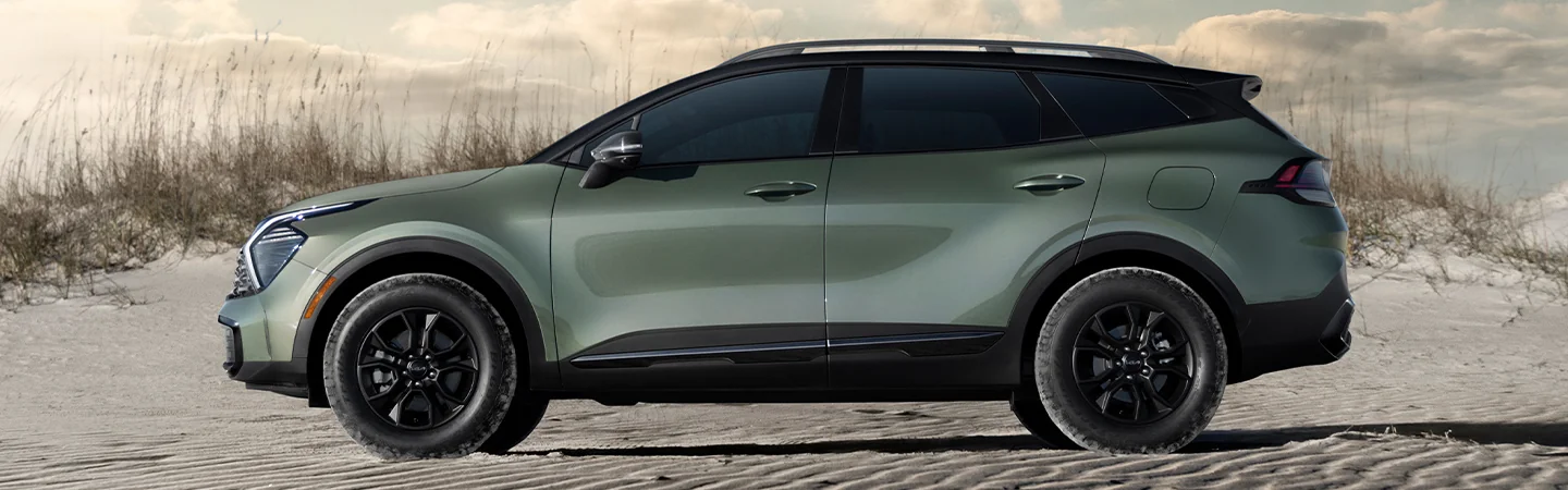 Side view of a parked 2025 Kia Sportage on sand