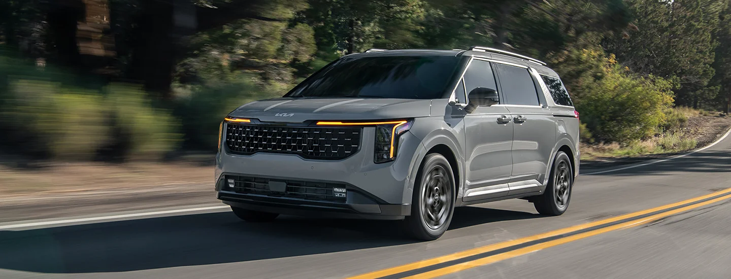 a front driver side view of a gray 2026 Kia Carnival LX