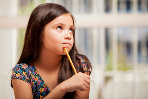 Young student thinking hard with pencil a pencil in hand.