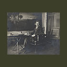 George Inness seated in his studio