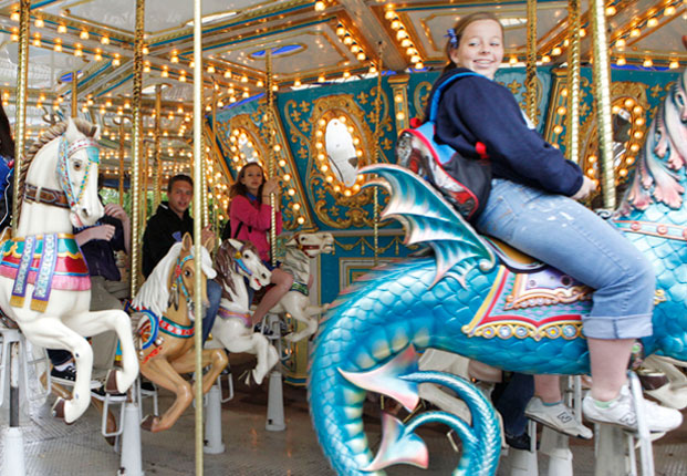 Young people ride on the carousel during the opening day at Frontier City.