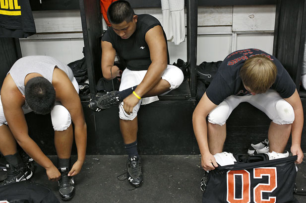 Stephen Cully and his teammates get dressed before practice in the locker room at Konawa High School in Konawa, Okla., on Monday, Aug. 29, 2011.