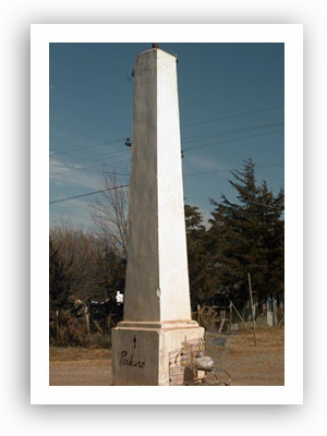 The Indian Meridian obelisk stands in the middle of a Langston intersection. It marks the Ozark trail, which settlers traveled more than 100 years ago, and is the point in Oklahoma from which all distances are measured. In the years since this photograph was taken, the paint pointing the way to Perkins has faded or chipped away.