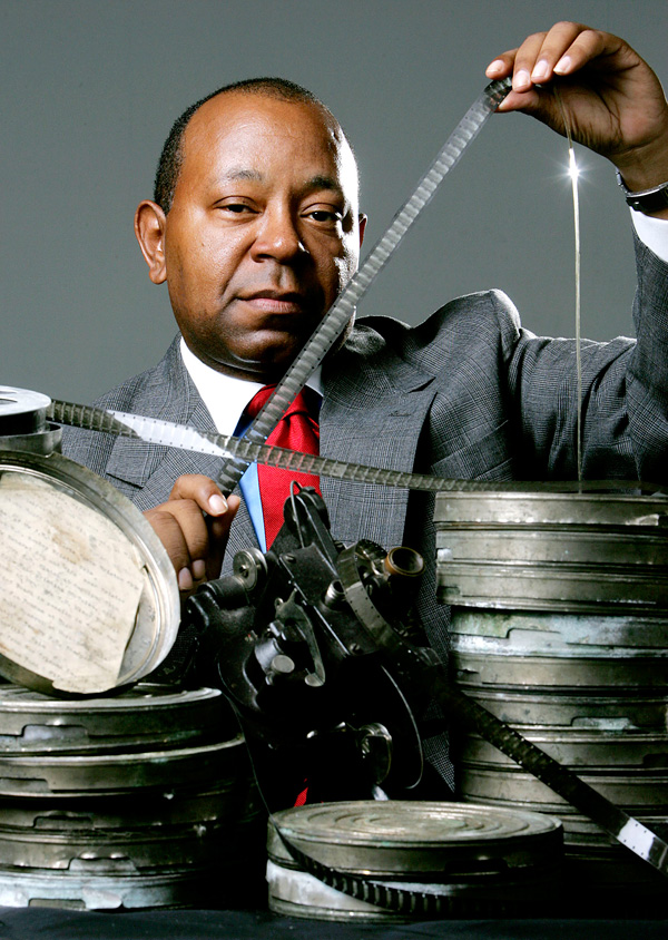 Currie Ballard poses with 29 cans of film he recently purchased from a collector, at The Oklahoman studio in Oklahoma City, Wednesday, Sept. 20, 2006. The films show blacks in the 1920s including a graduation at Langston University, a funeral procession at Hugo, and a cattle ranch at Bristow.