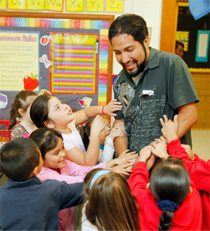 Students at Shidler Elementary clamor for the attention of Miguel Rayos during his recent visit to his alma mater as a volunteer.