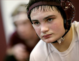 Perry sophomore Matt Manley takes in a lesson from head coach Scott Chenoweth who said his primary objective as a coach is to make his wrestlers self motivated to train.