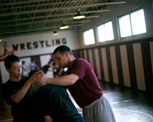 Assistant coach Ronnie Delk instructs a pair of middle school wrestlers during a recent practice. The middle school program has always been important stepping stone and where exceptional talent is identified and developed at an early age