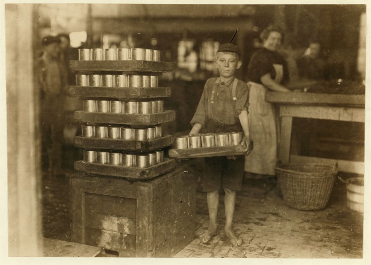 One of the small boys in J. S. Farrand P[ac]king Co. and a heavy load. J. W. Magruder, witness. Location: Baltimore, Maryland. 1909 July. (Lewis Hine/Photo courtesy LOC)