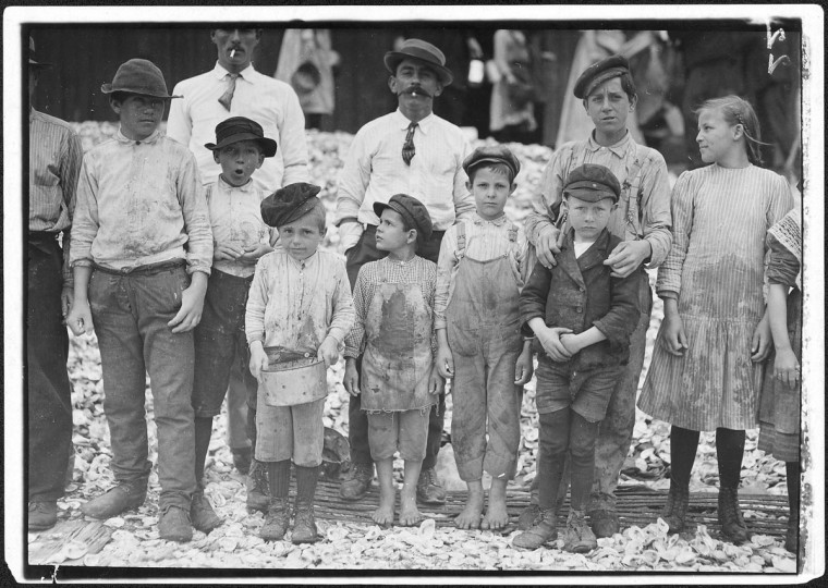 Original Caption: All these are shrimp pickers. Youngest in photo are 5 and 8 years old. Biloxi, Miss, February 1911. (Lewis Hine/Photo courtesy of NARA)