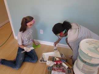 St. Thomas Mission Workers Young women from St. Thomas paint wall during springbreak mission trip to Mississippi
