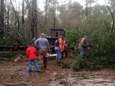 Friends remove debris from a driveway in Petal