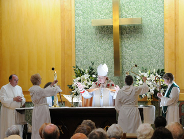 Bishop Ted Gulick blesses the altar in the new chapel. 
