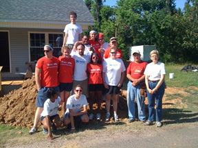2009 summer camp staff poses in front of Habitat house