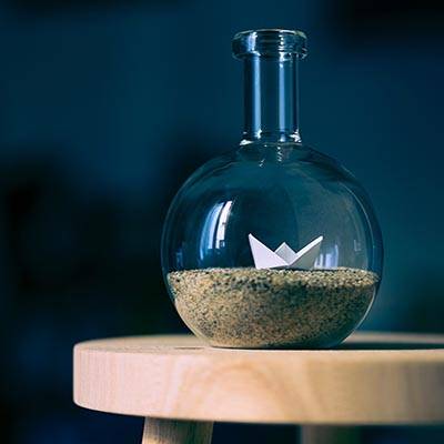 Beaker with sand and origami inside