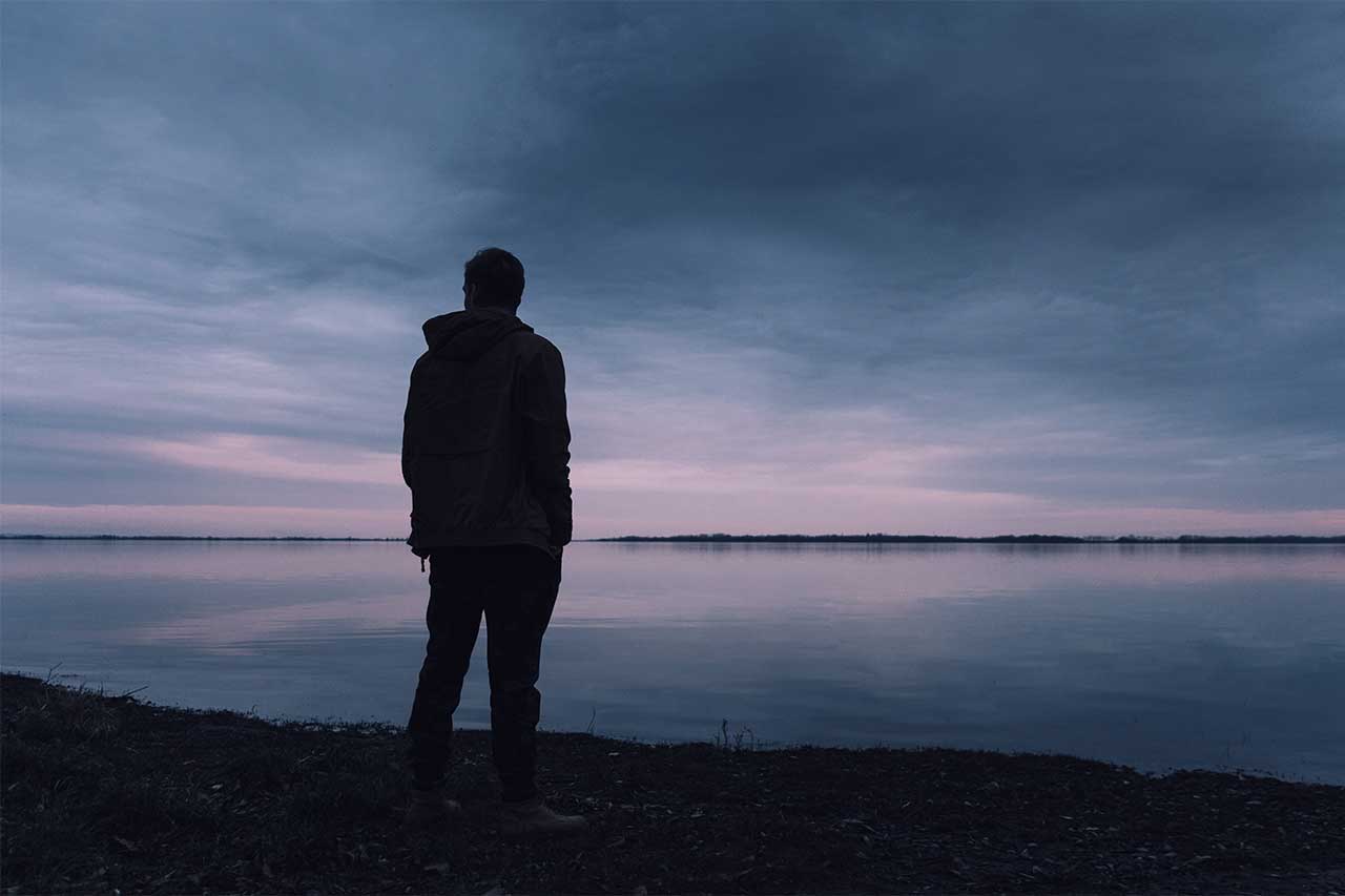 Man thinking, in shadow, alone
