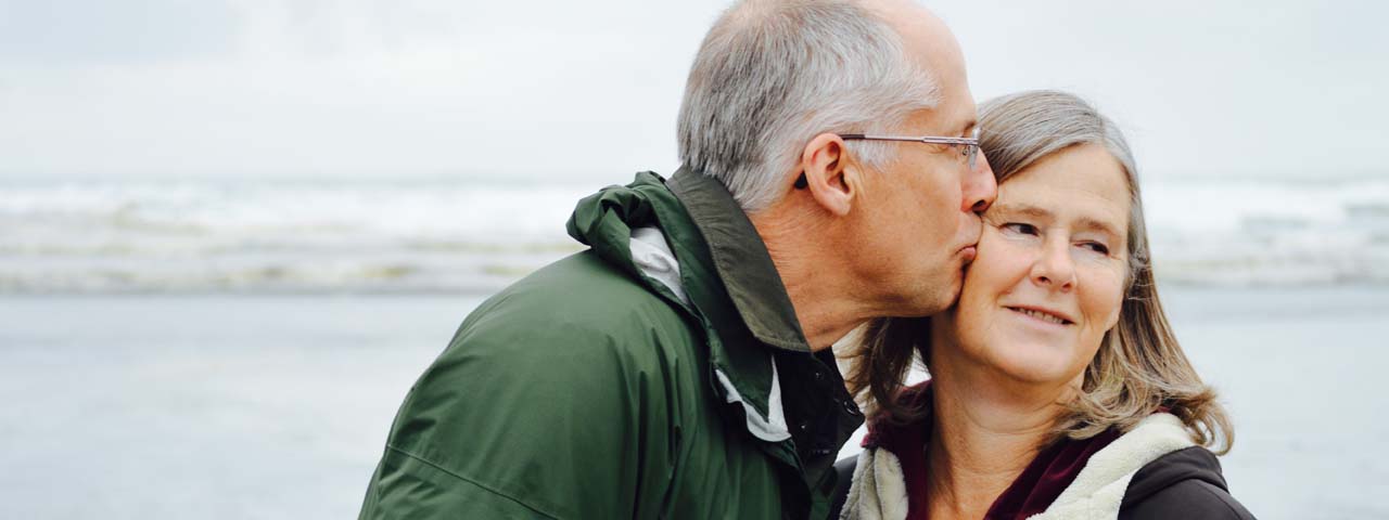 senior man with glaucoma, kissing wife