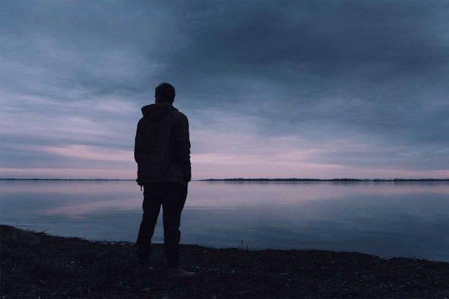 Man thinking, in shadow, alone
