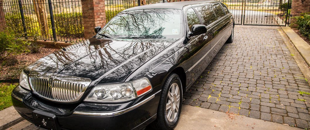 Lincoln Town Car Limousine in front of a gate