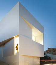House on mountainside overlooked by castle
