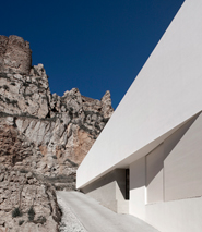 House on mountainside overlooked by castle