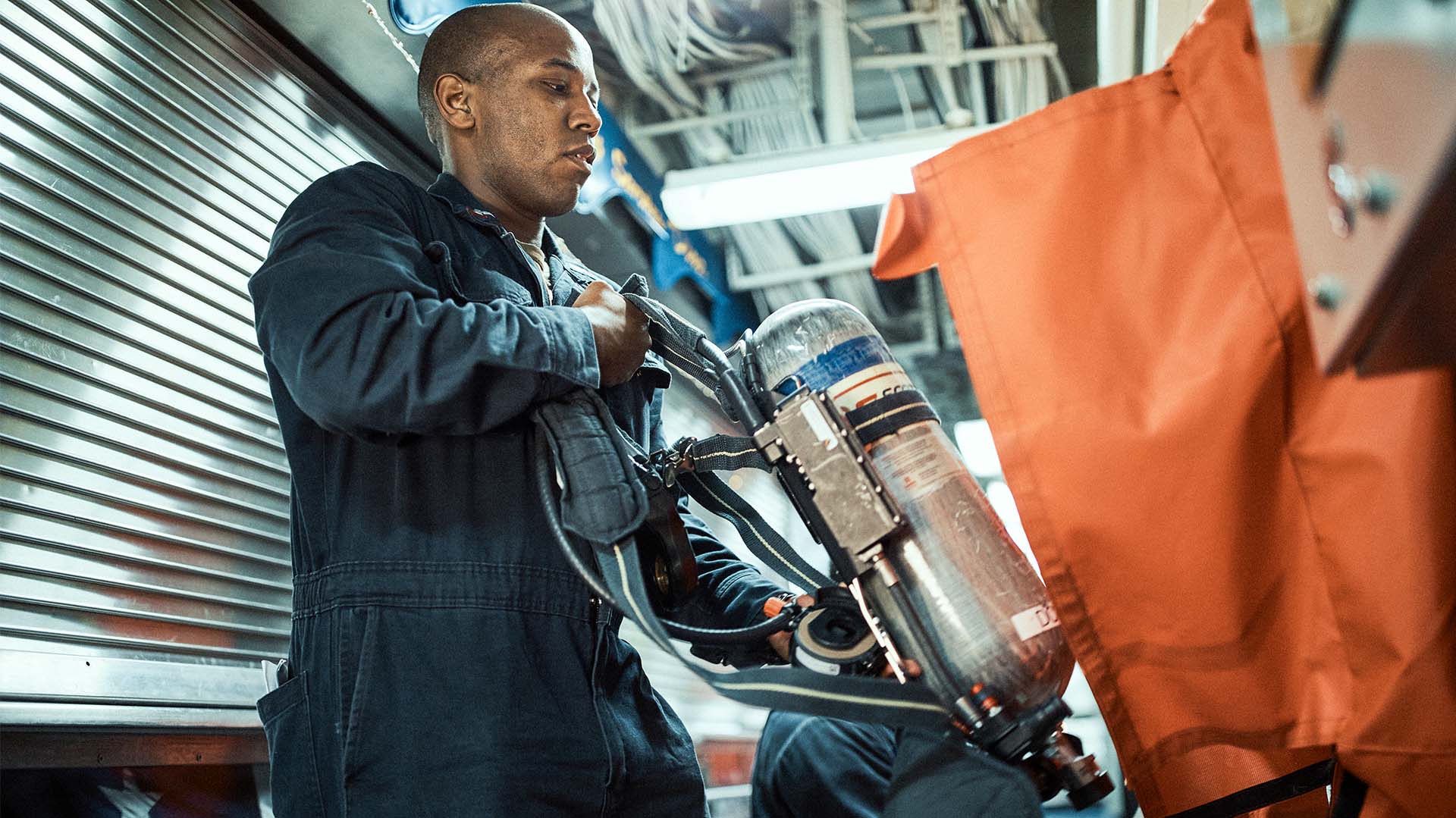 Sidney Wilson bent over smiling while getting his helmet 
