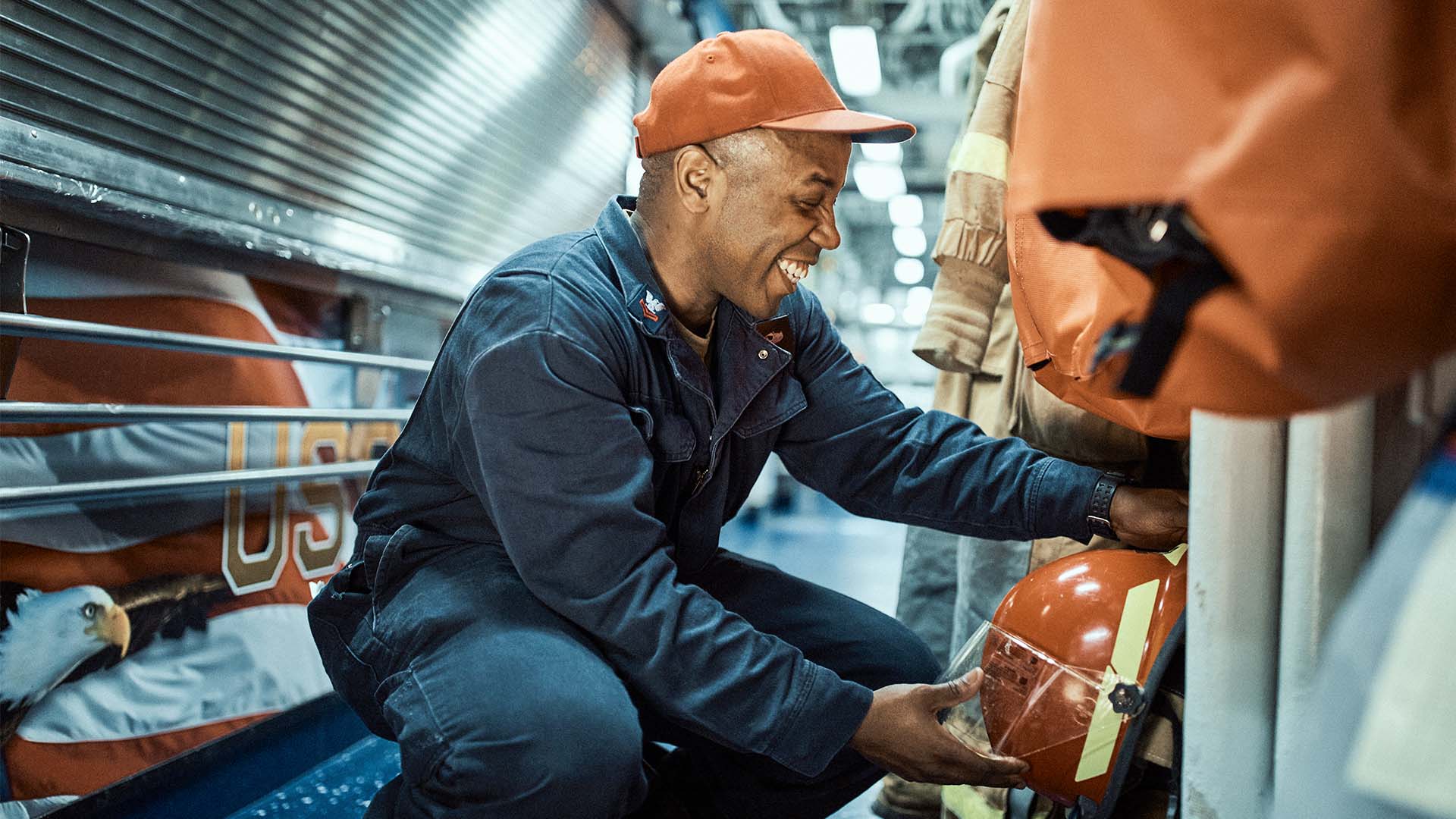 Sidney Wilson bent over smiling while getting his helmet 