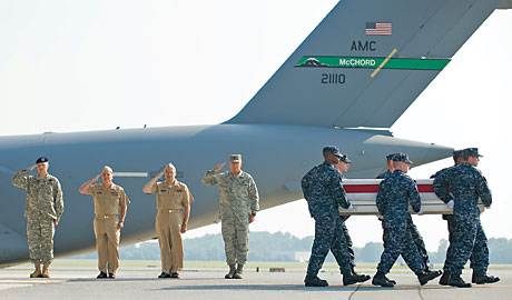 A Navy carry team takes a transfer case containing the remains of Seaman William F. Ortega