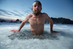 man bathing in ice hole