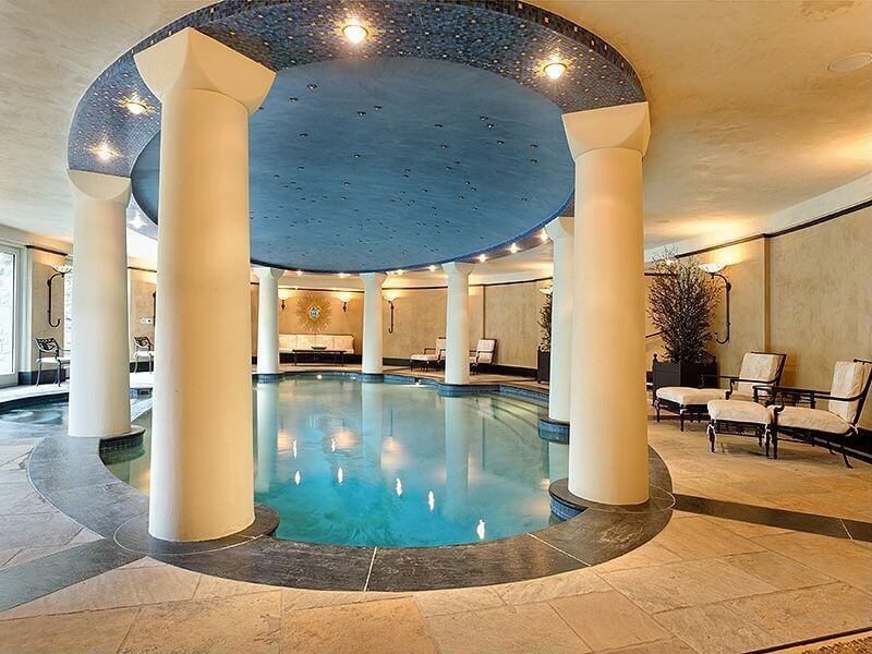 Large luxury indoor pool in Roman bath design with columns surrounding the oval pool. Large luxury indoor pool in Roman bath design with columns surrounding the oval pool.
