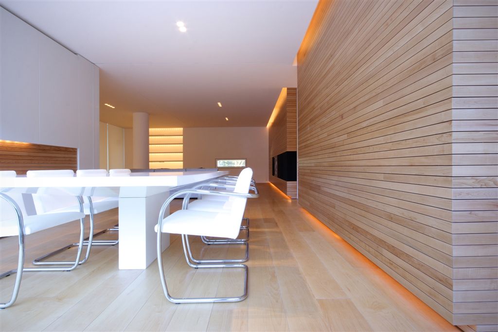 Straight on view of dining and living areas. Hidden light sources at top and bottom of walls. Straight on view of dining and living areas. Hidden light sources at top and bottom of walls.