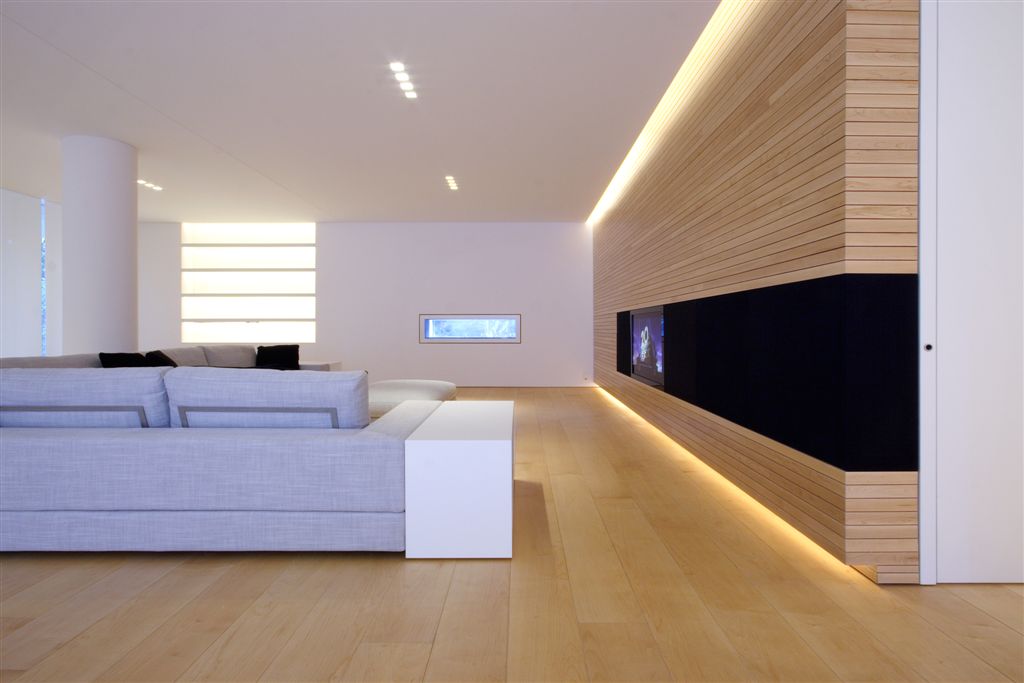 Opposite angle of living room, highlighting grey couch with white end table, small window at far end. Opposite angle of living room, highlighting grey couch with white end table, small window at far end.