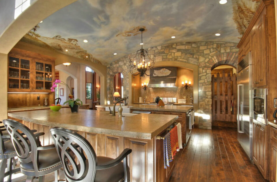 The kitchen is impressive in design featuring two islands, wood flooring, stone walls and a blue-sky mural ceiling The kitchen is impressive in design featuring two islands, wood flooring, stone walls and a blue-sky mural ceiling