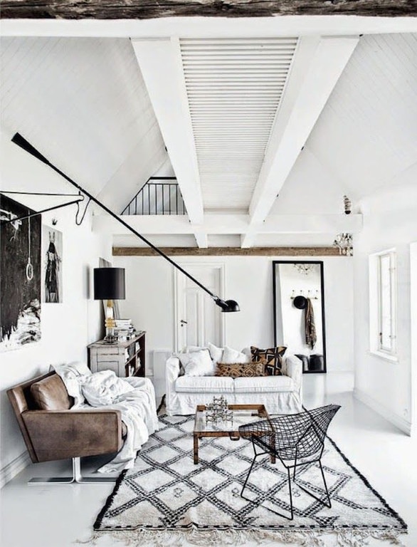 This living room looks slightly rustic but still cool; the combination of white and black is always beautiful. The leather sofa is covered with white cloth while the white floor is spread with a patterned floor rug.