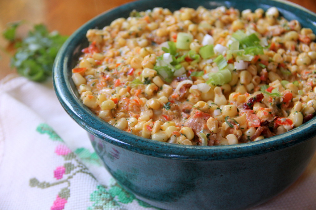 Mexican creamed corn with jalapenos, bacon, scallions, and cilantro is a great side dish for a potluck or cookout.