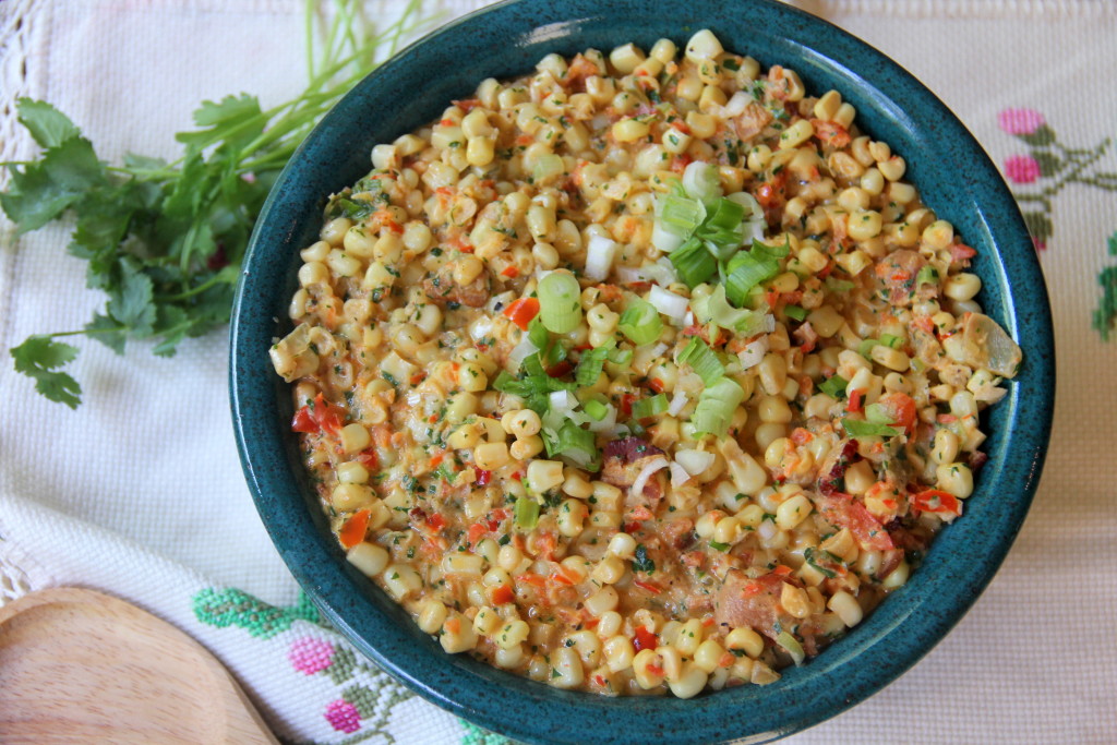Mexican creamed corn with jalapenos, bacon, scallions, and cilantro is a great side dish for a potluck or cookout.
