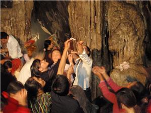 Catching drips from the limestone cave ceiling with money