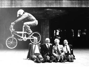 A BMX rider jumps over a group of dignitaries