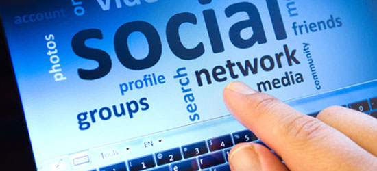 Image of a screen with social media words with a finger pointing tot he words.