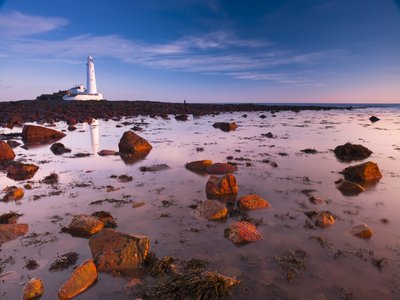 Fine Art Print of St Mary's lighthouse, over rocky shoreline by Assaf Frank