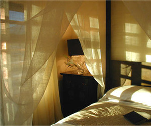 Bed-draped-in-natural-fiber-textiles-m