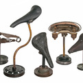 Group-of-5-vintage-bicycle-seats-mounted-on-rustic-stands-s