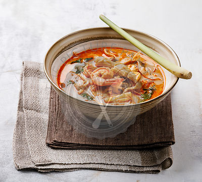 Tom Yam kung Spicy Thai seafood soup with shrimp, coconut milk and lemon grass in casserole dish