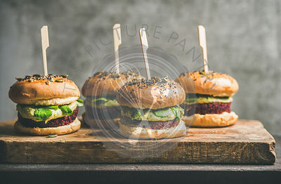 Vegan burgers with beetroot patties and green sprouts on board